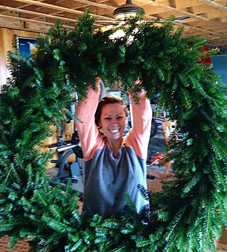 Wreath Master Kelly peeks through a jumbo-sized wreath being made down in Uncle Steve's wreath shop.